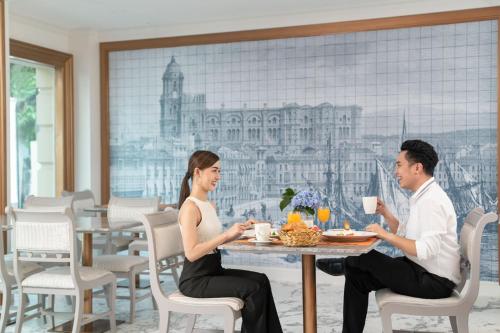 a man and woman sitting at a table in a restaurant at Kingston Suites Bangkok in Bangkok