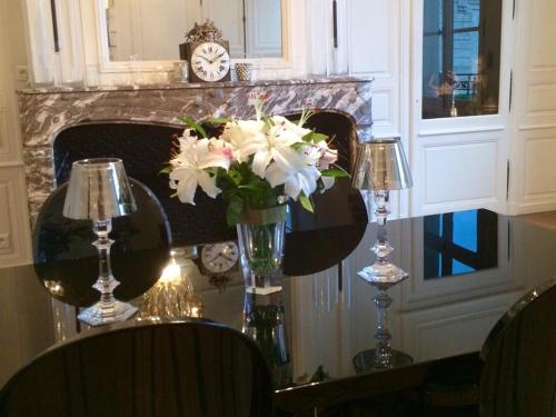 a dining room table with a vase of flowers on it at La Maison Dans le Parc in Saint-Dizier