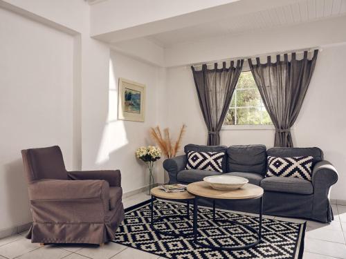 uma sala de estar com um sofá e uma mesa em Periyali Villas with Private Pools em Vasilikos