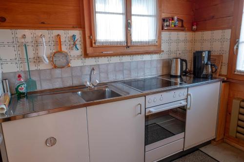 een keuken met een wastafel en een fornuis bij Chalet Elisabeth in Rosswald