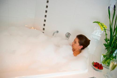 a woman in a bathtub filled with foam at Scone Motor Inn & Apartments in Scone