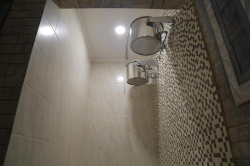 a bathroom with two lights on the wall at Hotel Ashad in Svalyava