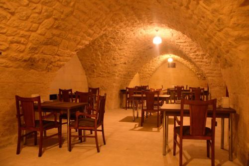 a dining room with tables and chairs in an old building at CİHANGİR KONAĞI BUTİK OTEL in Sanlıurfa