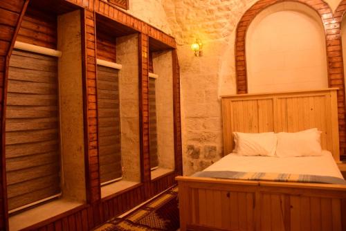 Cama en habitación con 2 ventanas en CİHANGİR KONAĞI BUTİK OTEL en Sanlıurfa