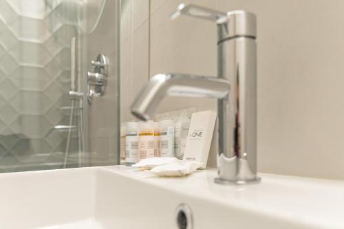 a bathroom counter with a sink and a faucet at Hotel Boston in Bari