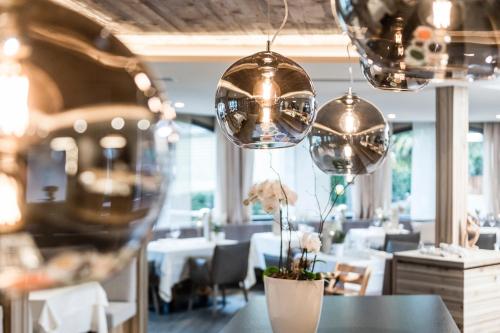 a dining room with tables and chairs and lights at Hotel Zirmerhof & Residence in Rifiano