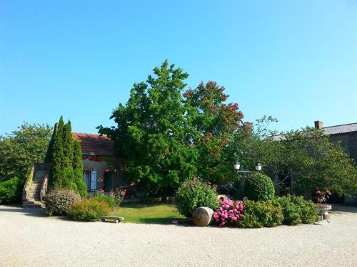 une maison avec un grand arbre dans la cour dans l'établissement Château de la Galissonnière, au Pallet