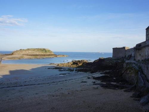 a view of a beach with an island in the water at Intra Muros Vue Mer in Saint Malo