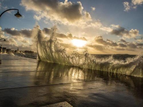 サン・マロにあるIntra Muros Vue Merの太陽を背景とした海の波