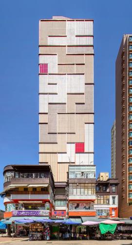 a tall building in front of two tall buildings at Hotel 1936 in Hong Kong