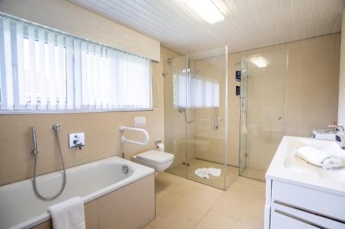 a bathroom with a tub and a toilet and a shower at Haus Alpsee in Immenstadt im Allgäu