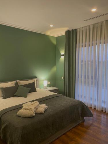 a bedroom with a large bed with green walls at Royal Rest 