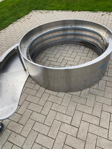 a large metal fire pit on a brick patio at Ferienwohnung am Deichweg in Cappel-Neufeld