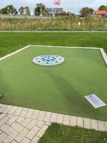 a frisbee golf game on a grass field at Ferienwohnung am Deichweg in Cappel-Neufeld