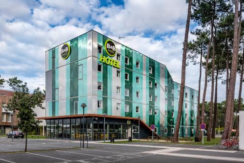a large green building with a sign on it at B&B HOTEL Arcachon Gujan-Mestras in Gujan-Mestras