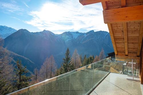 a glass balcony with a view of mountains at Chalet Avista in Rosswald