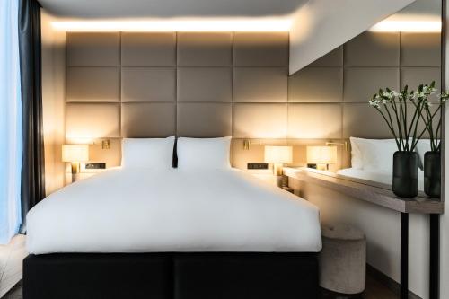 a bedroom with a large white bed and a wall at Crowne Plaza - Warsaw - The HUB by IHG in Warsaw