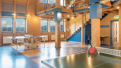 a large room with a table and a staircase at Hapimag Ferienwohnungen Sonnleitn in Sonnenalpe Nassfeld