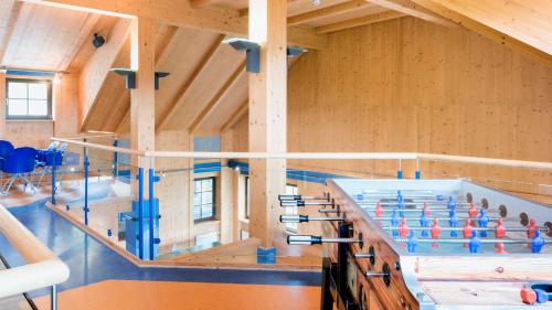 a large room with a swimming pool with blue chairs at Hapimag Ferienwohnungen Sonnleitn in Sonnenalpe Nassfeld