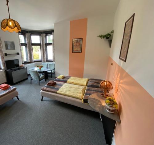 a bedroom with a bed and a living room at Penzion Akron in Tanvald