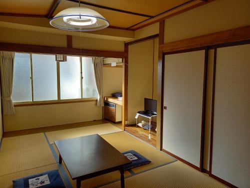 sala de estar con mesa y ventana en Stayful House Nakamachi, en Hakuba