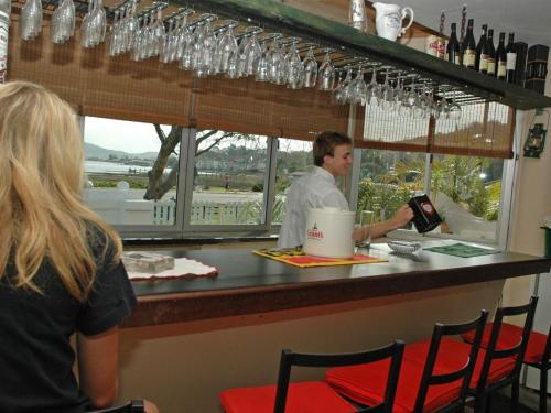 a man and a woman sitting at a bar at Lagoona Inn in Knysna