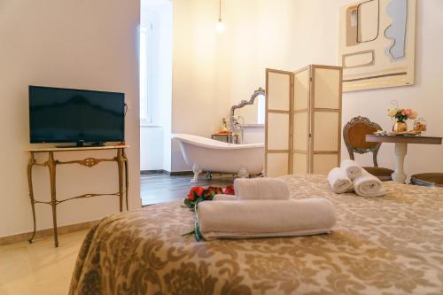 een badkamer met een bad en een bed met handdoeken bij Corte Pietrantica - Charming Rooms & Suites in Giovinazzo