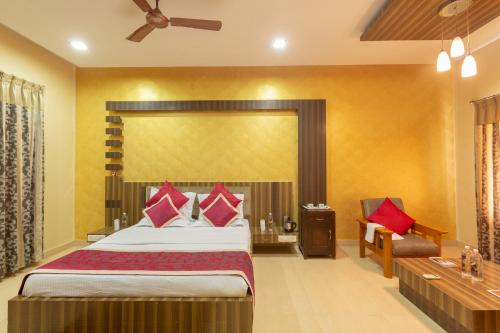 a bedroom with a large bed with red pillows at KSTDC Hotel Mayura Gerusoppa, Jogfalls in Māvingundi