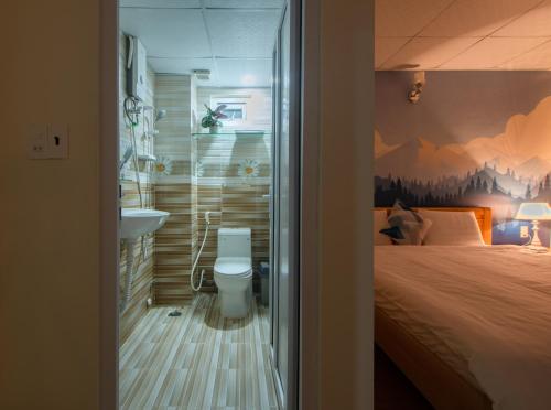 a bedroom with a bed and a sink and a toilet at Moc Thach Hostel Dalat in Da Lat
