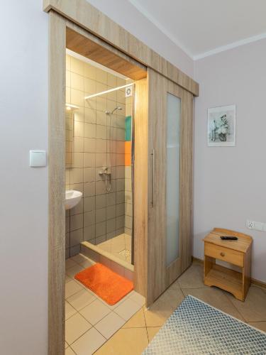 a bathroom with a shower with a glass door at Gościniec u Sary in Jastrzębia Góra