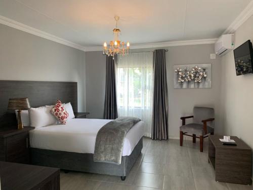 a bedroom with a bed and a chandelier at Airport lodge Newcastle in Newcastle