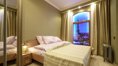 a bedroom with a bed and a window with a view at OldRigaLuxApart free parking in Riga