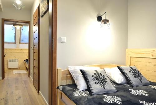 a bedroom with a bed with pillows on it at Biathlon Park - Apartament VIP in Kościelisko