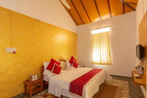 a bedroom with a large bed with red pillows at KSTDC Hotel Mayura Gerusoppa, Jogfalls in Māvingundi