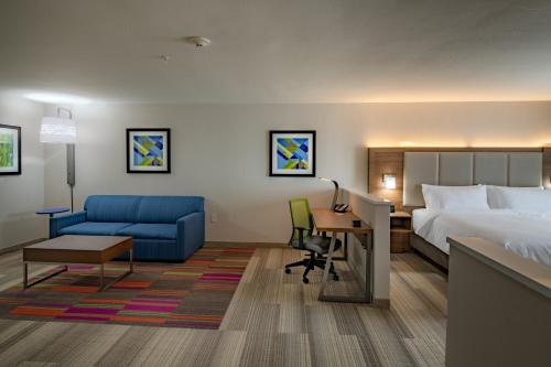 WestにあるHoliday Inn Express & Suites N Waco Area - West by IHGのベッドと机があるホテルの部屋