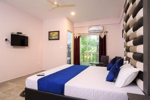 a bedroom with a large bed and a window at Casa Da Village Calangute Goa in Calangute