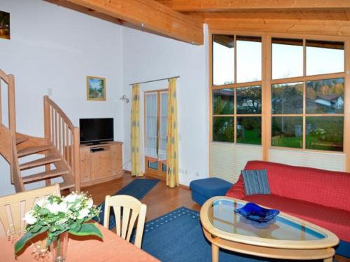 a living room with a red couch and a table at Ferienwohnungen und Ferienhaus Kronner in Zachenberg