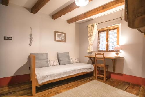 Villarodin-BourgetにあるAu Coeur Des Alpesのデスク、窓が備わるドミトリールームのベッド1台分です。