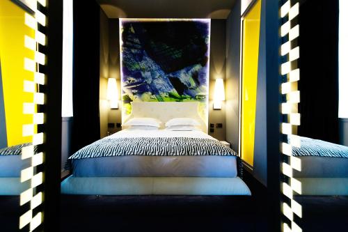 a bedroom with a canopy bed with blue and yellow at Malmaison Hotel Leeds in Leeds