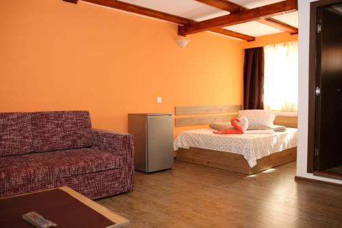 een woonkamer met een bank en een bed bij Pensiunea Lala in Băile Tuşnad