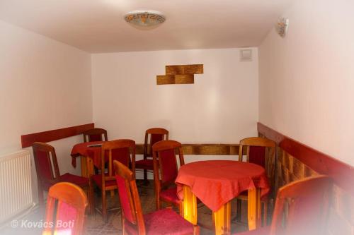 a dining room with tables and chairs with red table cloth at Pensiunea Lala in Băile Tuşnad