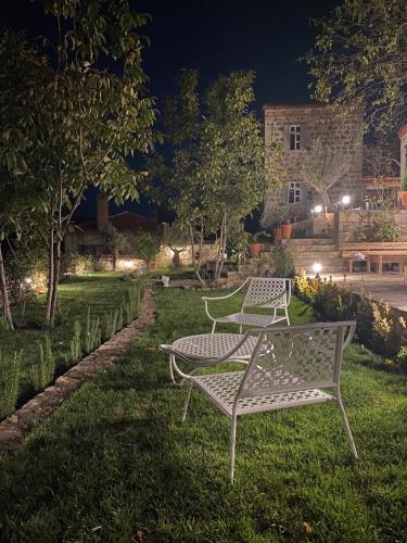 deux bancs blancs assis dans l'herbe la nuit dans l'établissement Perlacia Hotel Adatepe, à Adatepe