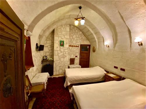 a room with two beds in a room with an arch at Sofa Hotel in Avanos