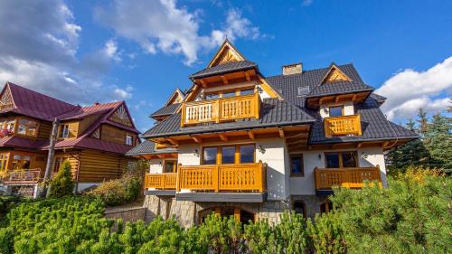 duży drewniany dom z dachem gambrel w obiekcie Villa Delta Boutique w mieście Kościelisko