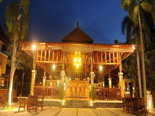 a large wooden pavilion with tables and chairs at night at Le Dian Hotel in Serang