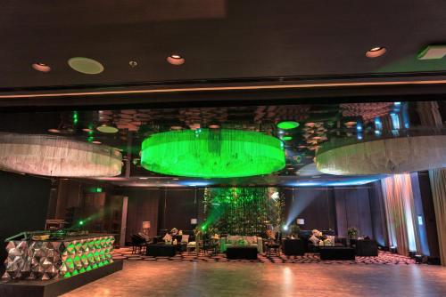 a large room with a green stage with tables and chairs at InterContinental Dhaka by IHG in Dhaka