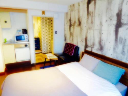 a bedroom with a bed and a couch and a kitchen at Dazaifu - Apartment / Vacation STAY 36932 in Dazaifu