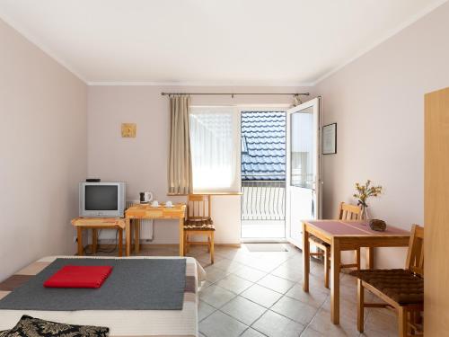 a living room with a table and a television at Gościniec u Sary in Jastrzębia Góra