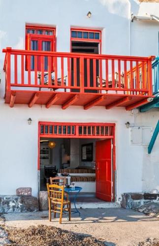 a building with a red balcony and a table and chairs at Dream Boathouse in Klima