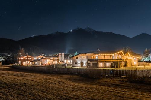a group of houses at night with mountains in the background at Löwen Chalets in Seefeld in Tirol